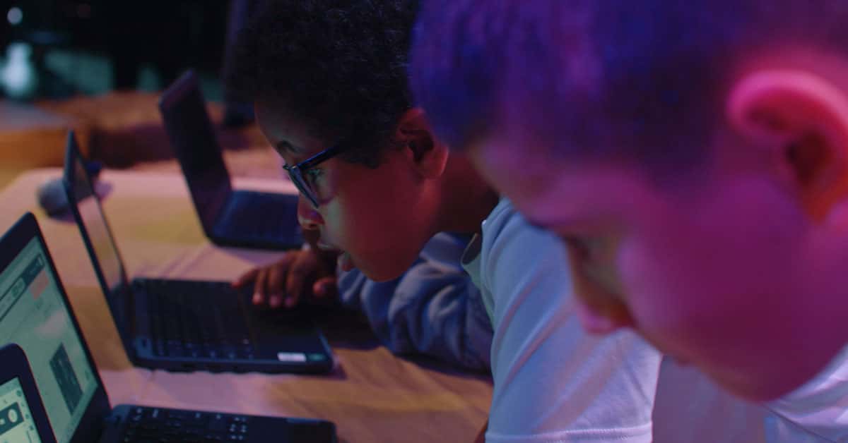 Students working on laptops in a classroom